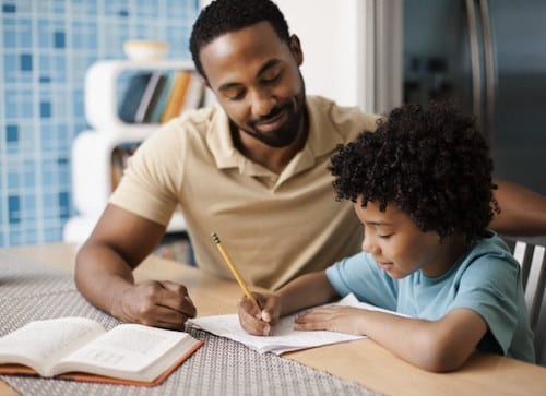 Father helping son (7-9) with homework
