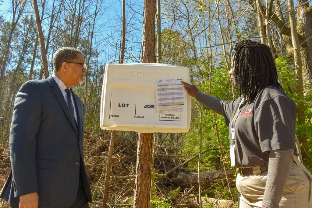 Mayor and Darkota in front of cell tower violation notice